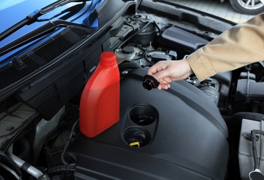 Photo of Man checking motor oil level in car, closeup