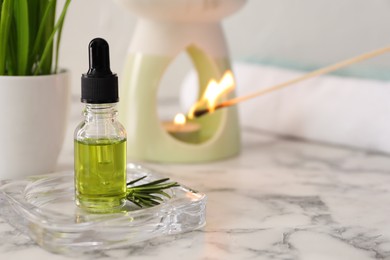 Aroma lamp and coniferous essential oil on white marble table, space for text