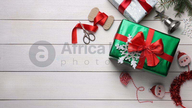 Flat lay composition with beautifully wrapped gift boxes on white wooden table, space for text