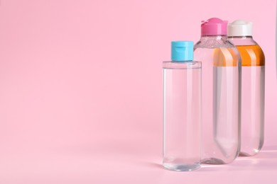 Bottles of micellar water on pink background. Space for text