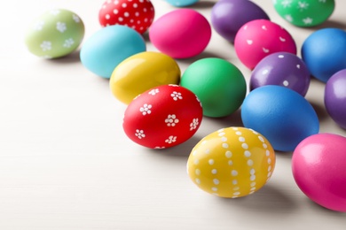Bright painted eggs on white wooden table. Happy Easter