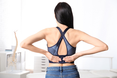 Woman suffering from lower back pain at clinic. Visiting orthopedist