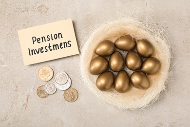 Golden eggs in nest, coins and card with phrase Pension Investments on light table, flat lay