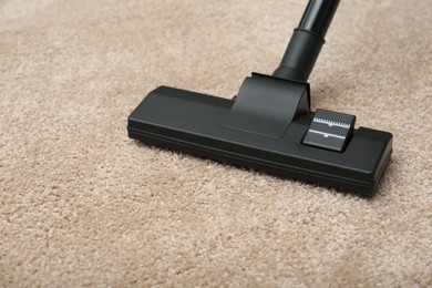 Photo of Removing dirt from carpet with modern vacuum cleaner indoors, closeup