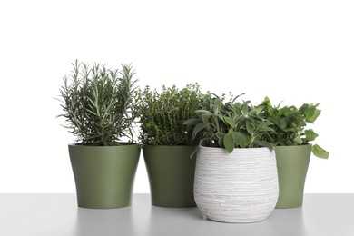 Pots with thyme, sage, mint and rosemary on white background