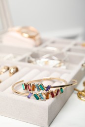 Beautiful bracelets in jewelry box on white table, closeup