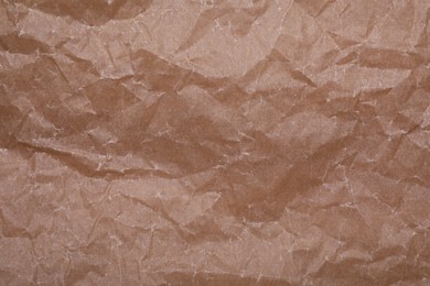 Texture of crumpled brown baking paper as background, top view