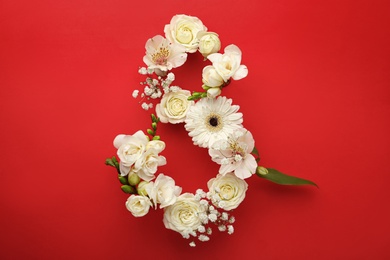 Number 8 made of beautiful white flowers on red background, flat lay. International Women's day