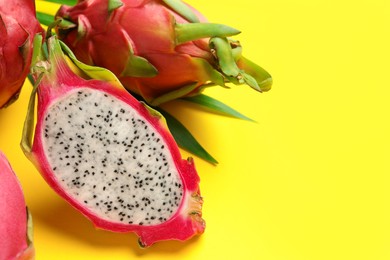 Photo of Delicious cut and whole white pitahaya fruits on yellow background. Space for text