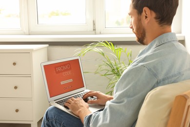 Photo of Man holding laptop with activated promo code at home