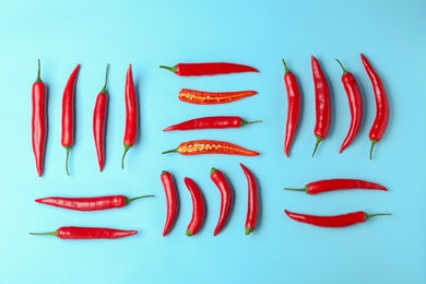 Flat lay composition with chili peppers on color background