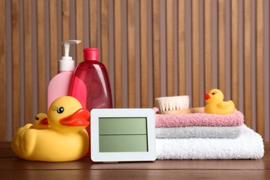Photo of Bathroom towels, toys and baby accessories on wooden table