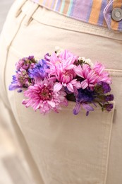 Woman wearing jeans with flowers in pocket, closeup