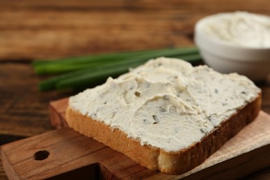 Delicious sandwich with cream cheese on wooden table, closeup