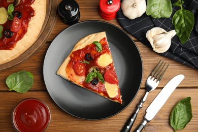 Slice of delicious pita pizza and ingredients on wooden table, flat lay