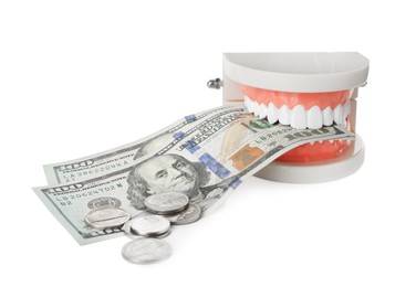 Educational dental typodont model, dollar banknotes and coins on white background. Expensive treatment