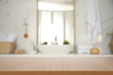 Empty wooden table and blurred view of stylish bathroom interior