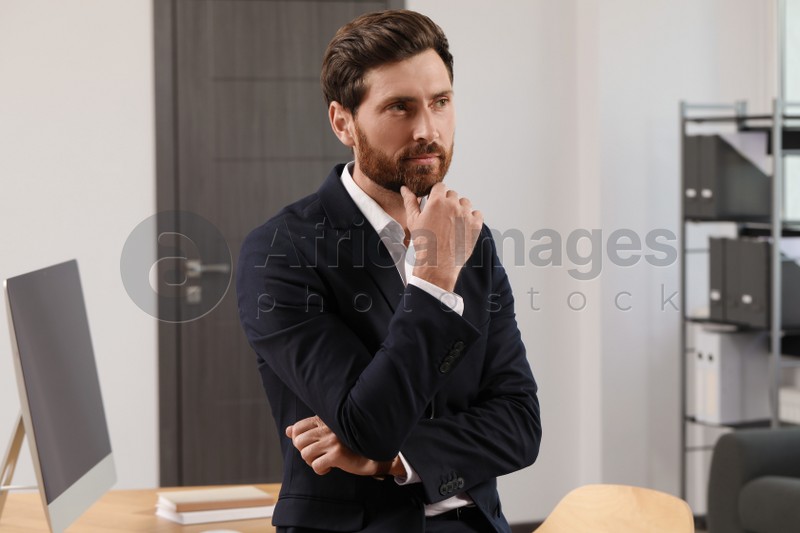 Portrait of handsome bearded man in office