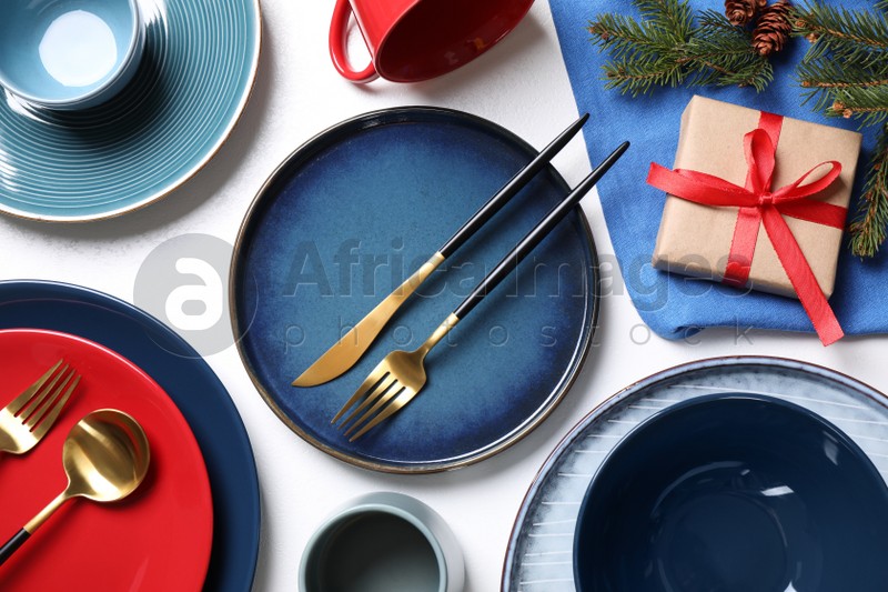 Flat lay composition with tableware, gift and fir branch on white background