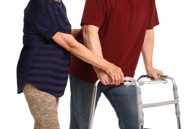 Photo of Elderly woman helping her husband with walking frame on white background, closeup