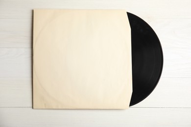 Vintage vinyl record in paper sleeve on white wooden table, top view