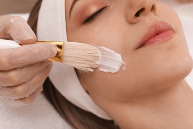Young woman during face peeling procedure in salon, closeup