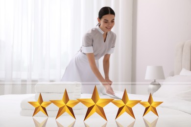 Chambermaid making bed in five star hotel room