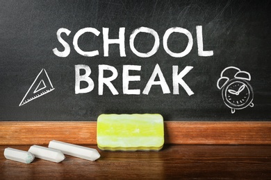 Image of Text School Break and drawings on black chalkboard near table. Seasonal holidays