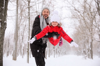 Father with his child having fun outside on winter day. Christmas vacation