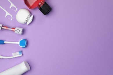 Flat lay composition with tongue cleaner and teeth care products on violet background, space for text