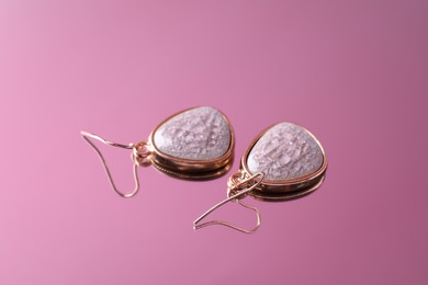 Beautiful earrings on mirror surface. Luxury jewelry