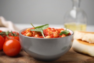 Photo of Delicious chickpea curry with basil in bowl, closeup