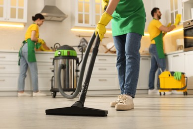 Professional janitors working in kitchen, closeup. Cleaning service