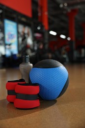 Medicine ball, bottle and weighting agents on floor in gym