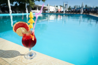 Tasty refreshing cocktail on edge of swimming pool. Party drink