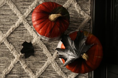 Orange pumpkins on rug, top view. Halloween decorations