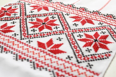 Photo of Traditional Ukrainian embroidery on white canvas, closeup. National handicraft