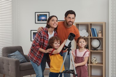 Photo of Happy family looking at stars through telescope in room