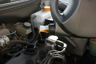 Pouring motor oil into car engine, closeup