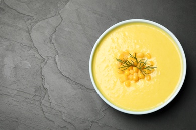 Delicious creamy corn soup on black table, top view. Space for text