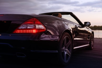 Photo of Luxury black convertible car outdoors in evening