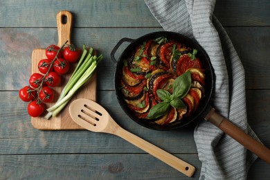 Photo of Delicious ratatouille and ingredients on light blue wooden table, flat lay