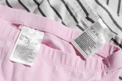 Photo of Clothing labels with instructions on garments, top view