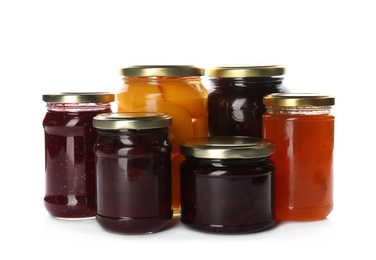 Glass jars with different pickled fruits and jams on white background