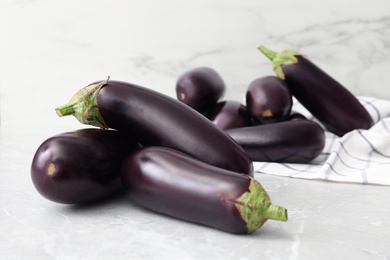 Many raw ripe eggplants on grey table