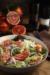 Bowl of delicious sicilian orange salad on wooden table, closeup. Space for text