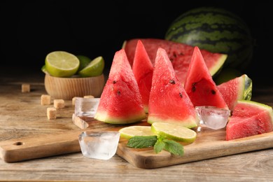 Tasty juicy watermelon, ice and lime slices on wooden table