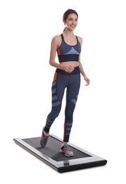 Sporty woman using walking treadmill on white background