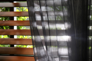 Window with beautiful curtain and blinds, closeup