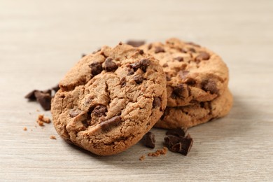 Photo of Delicious chocolate chip cookies on wooden table, closeup